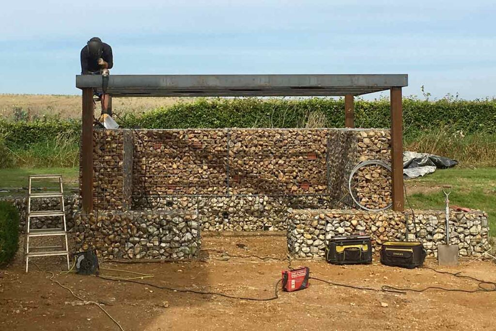 Unique Weathered Metal Pergola with Gabion Sides and Sedum Roof from 3A Steelworks
